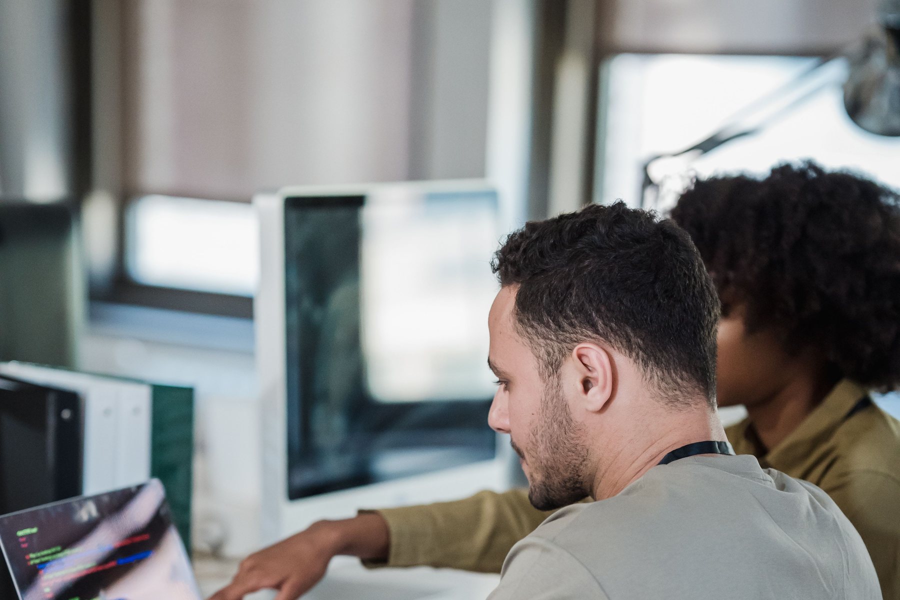 Équipe technique au travail sur du code dans un open space