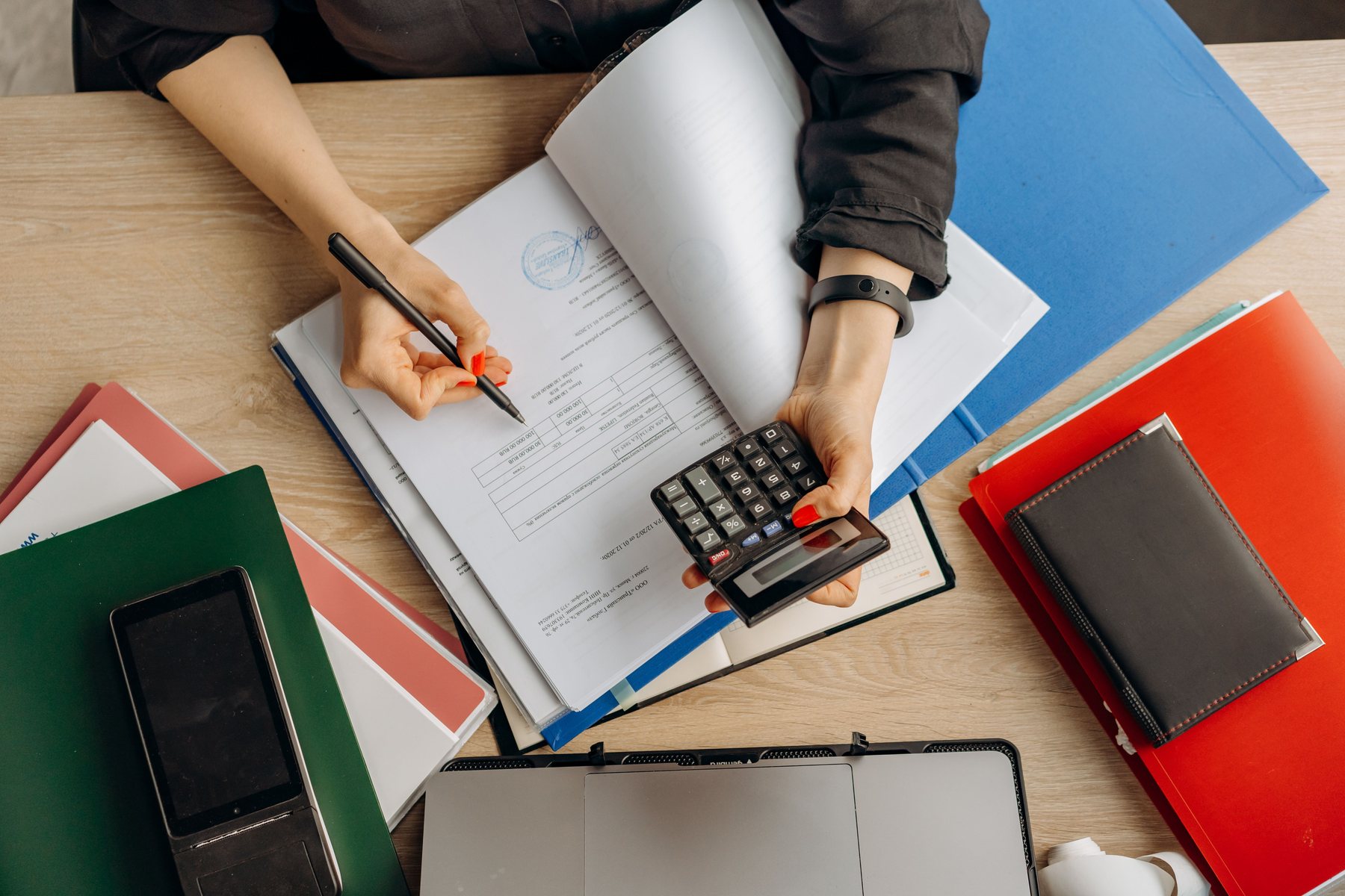 Analyse de documents financiers avec calculatrice sur un bureau