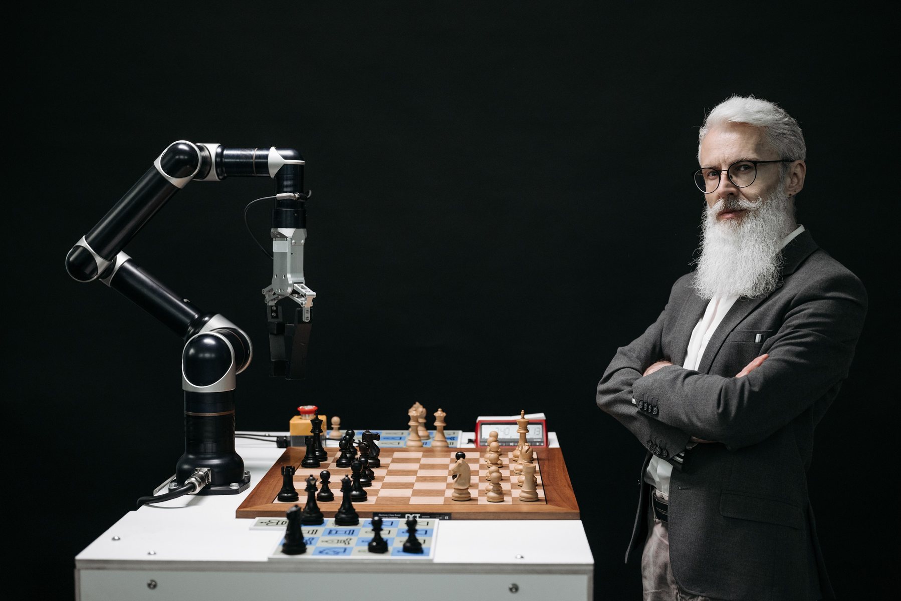 Bras robotisé jouant aux échecs face à un chercheur